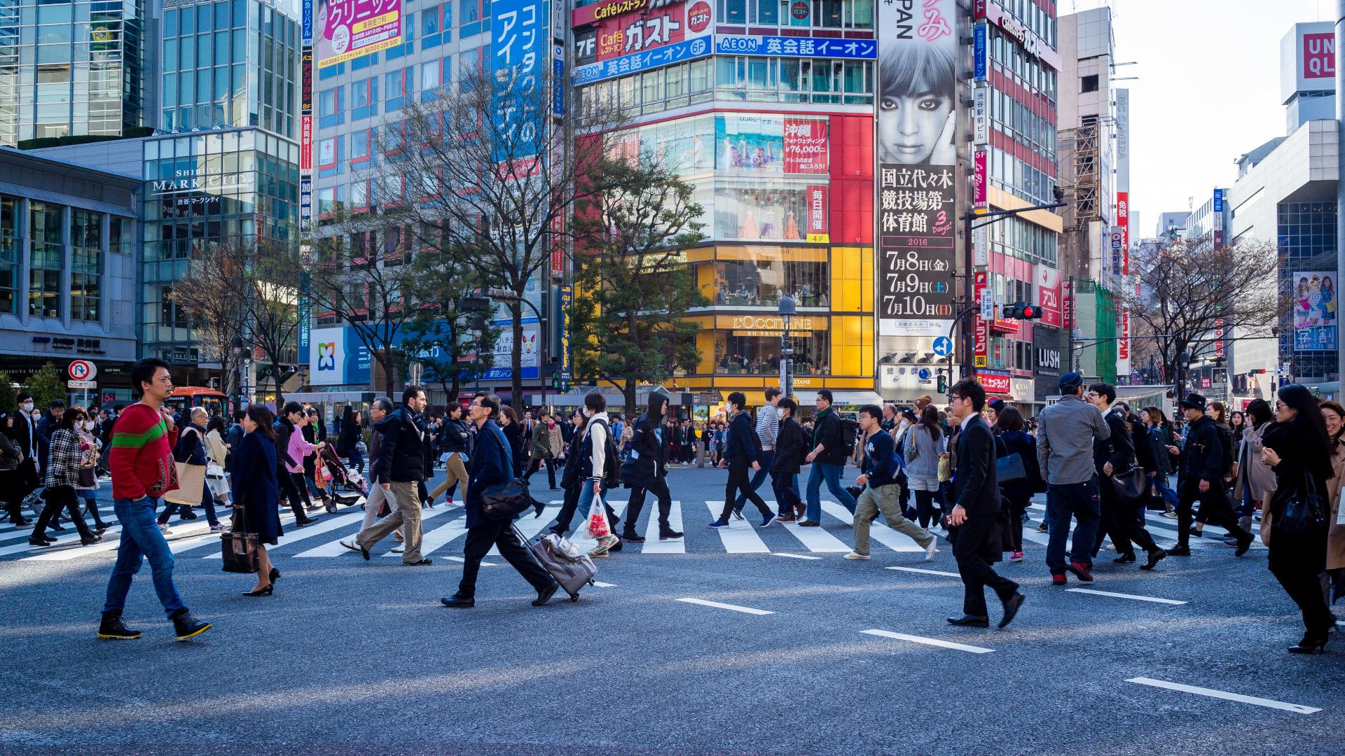 Menschen am Feierabend überqueren in Tokyo eine Kreuzung.